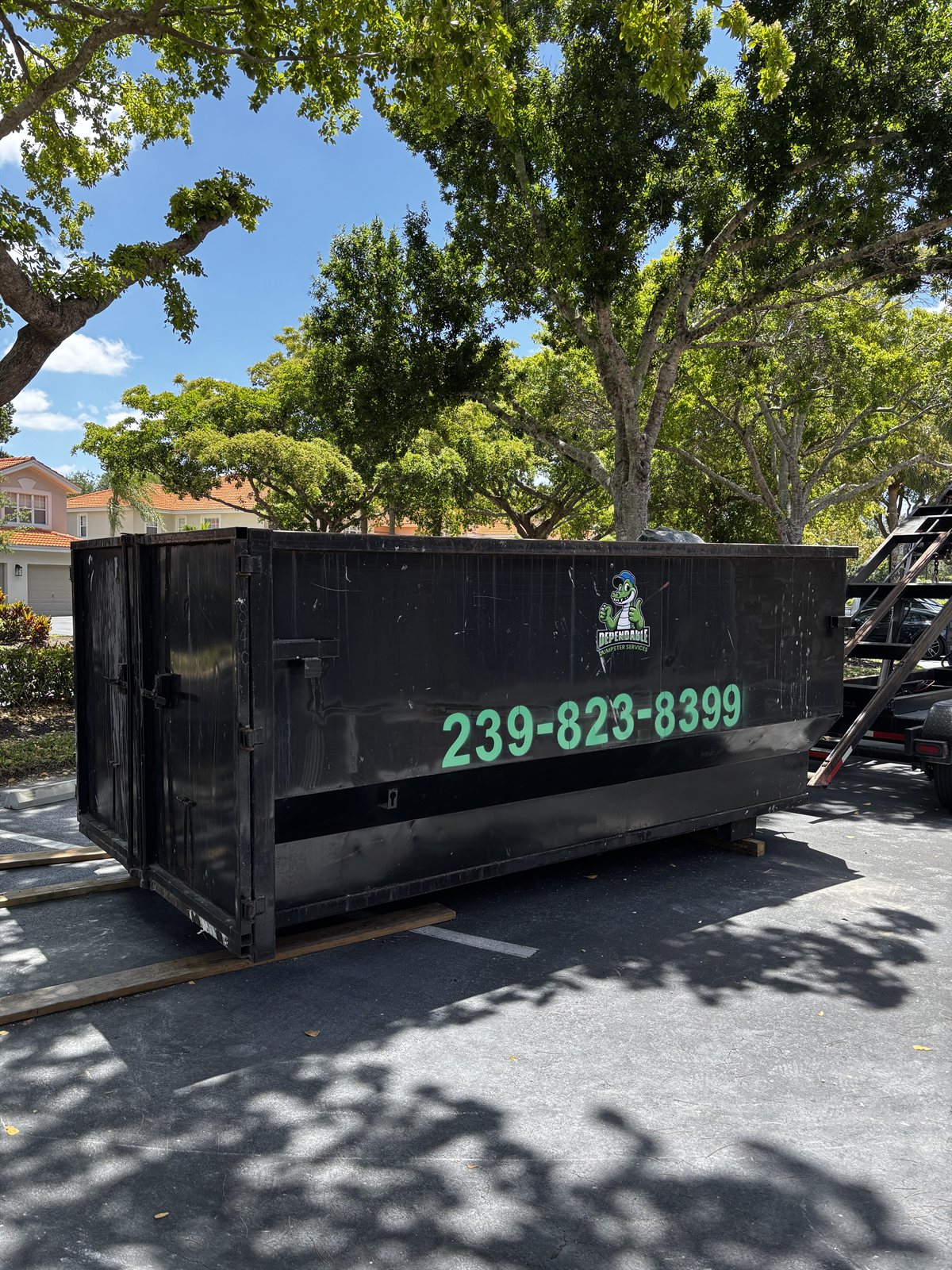 Dependable Dumpster Services 14-foot 20-yard roll-off dumpster in a residential parking area
