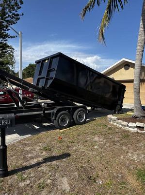 Dependable Dumpster Services trailer delivering a roll-off dumpster in Fort Myers, FL
